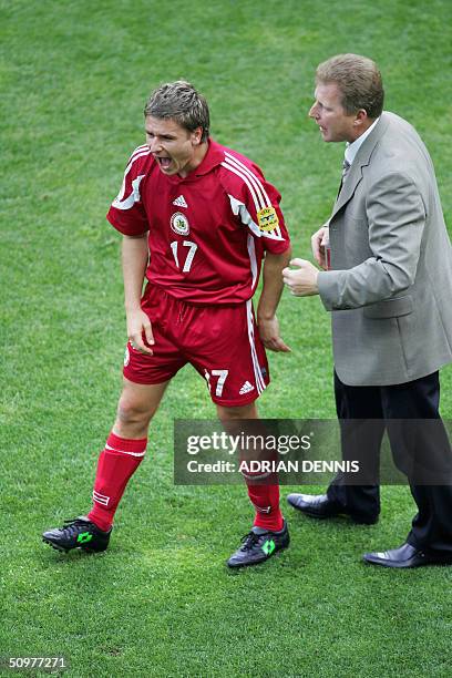 Latvian forward Marian Pahars celebrates with coach Aleksandrs Starkovs, 19 June 2004 after their European Nations football championships match at...