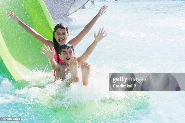 children on water slide - water slide stock pictures, royalty-free photos & images