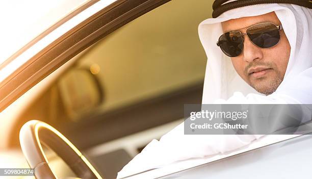 wealthy middle eastern arab in his luxury car - ghoutra stock pictures, royalty-free photos & images