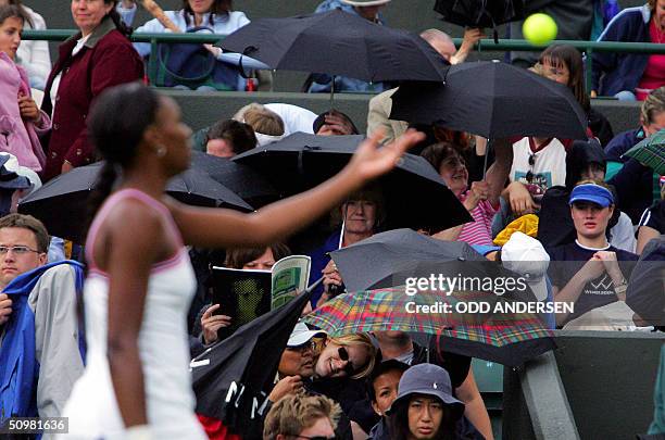 Venus Williams of the US tosses her ball as rain delays her match against Marie-Gayanay Mikaelian of Switzerland during the first round of the 118th...