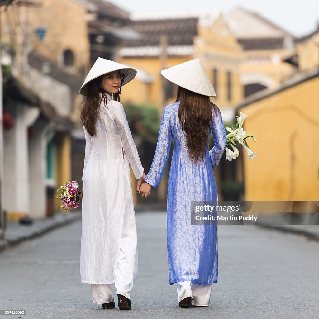 Vietnamese women walking along street
