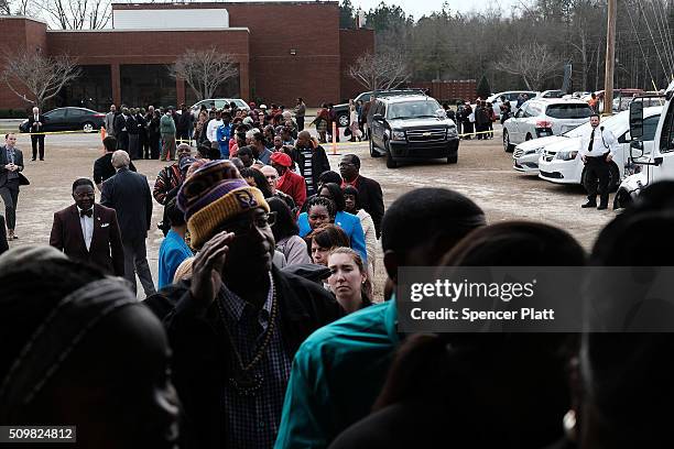 Residents wait to get into a school to see Democratic presidential candidate Hillary Clinton speak in South Carolina a day after her debate with...