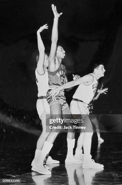 American basketball player Wilt Chamberlain , of the University of Kansas, is guarded by players from St Joseph's University during a game, 1956.