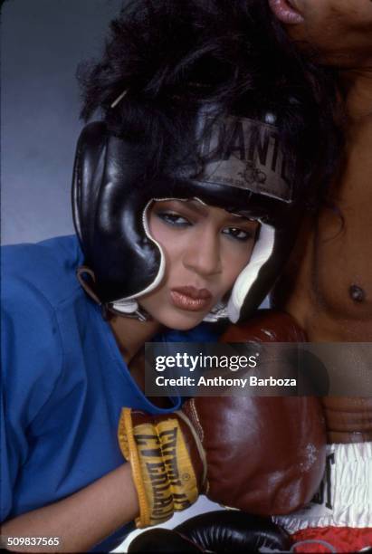 Close-up of model Tery Ferman, dressed in boxing gear, as she mimes a punch into the stomach of a man, New York, 1980s.