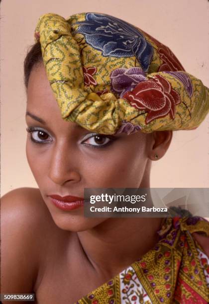 Portrait of model Sheila Johnson dressed in a print top and matching fabric headpiece, New York, 1970s.