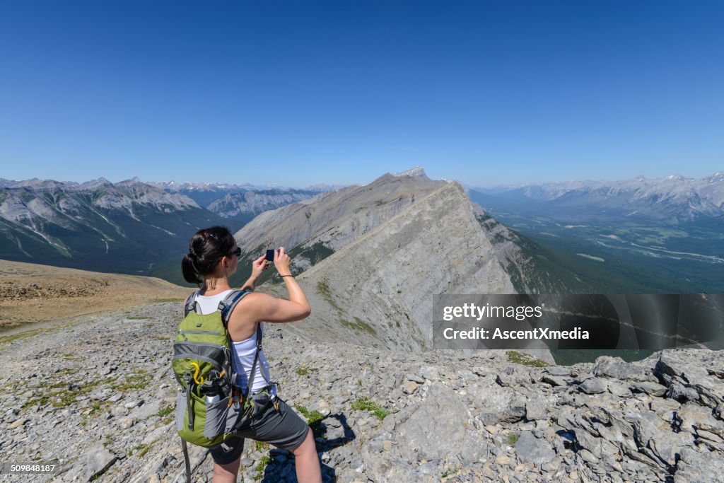 Woman takes smart phone picture from summit