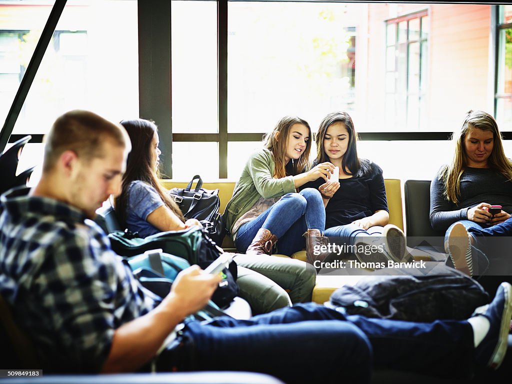 Students with smart phones in school common area