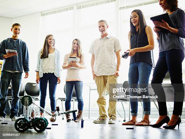 Female student operating robot in classroom