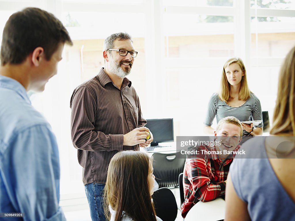 Smiling teacher in discussion with students