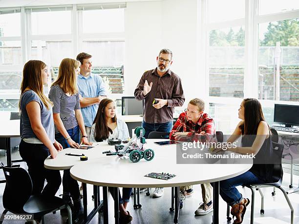 male teacher in discussion during robotics class - male teen tablet stock-fotos und bilder