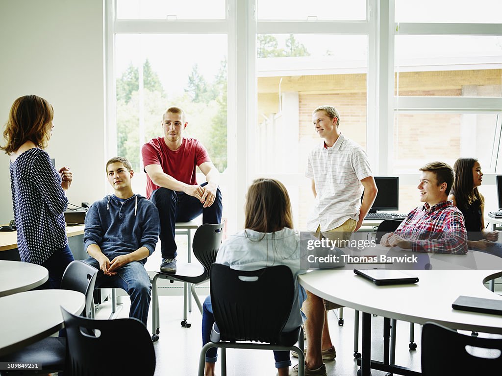 Female teacher in class discussion with students