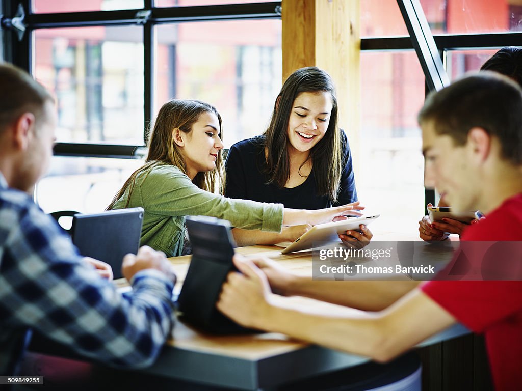 Students with digital tablets in school commons