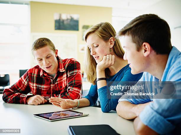 students in classroom working on digital tablet - checked shirt stock pictures, royalty-free photos & images