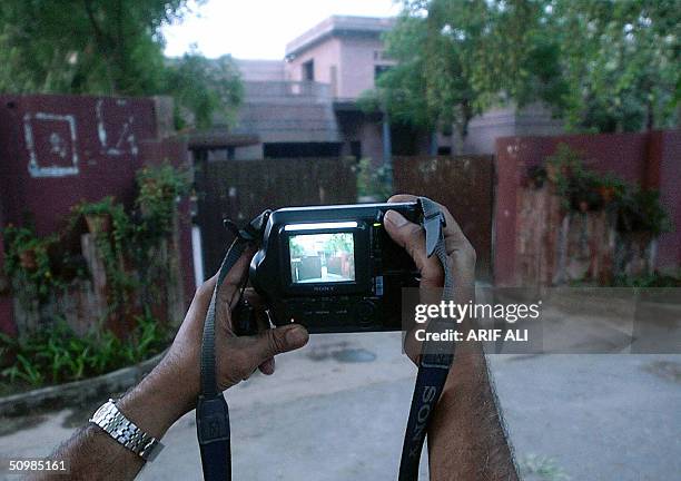 Pakistani journalist takes a photograph of the house of former Pakistani cricket hero Imran Khan, in Lahore, 22 June 2004. Khan and his British wife,...