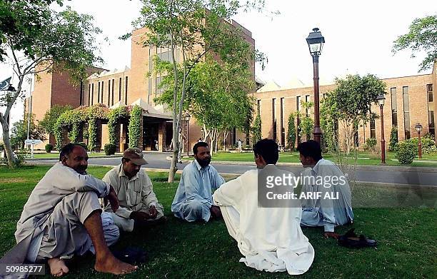 Group of Pakistani men talk as they sit infront of the Shaukat Khanum Memorial Cancer Hospital and Reseach Centre founded by former Pakistani cricket...