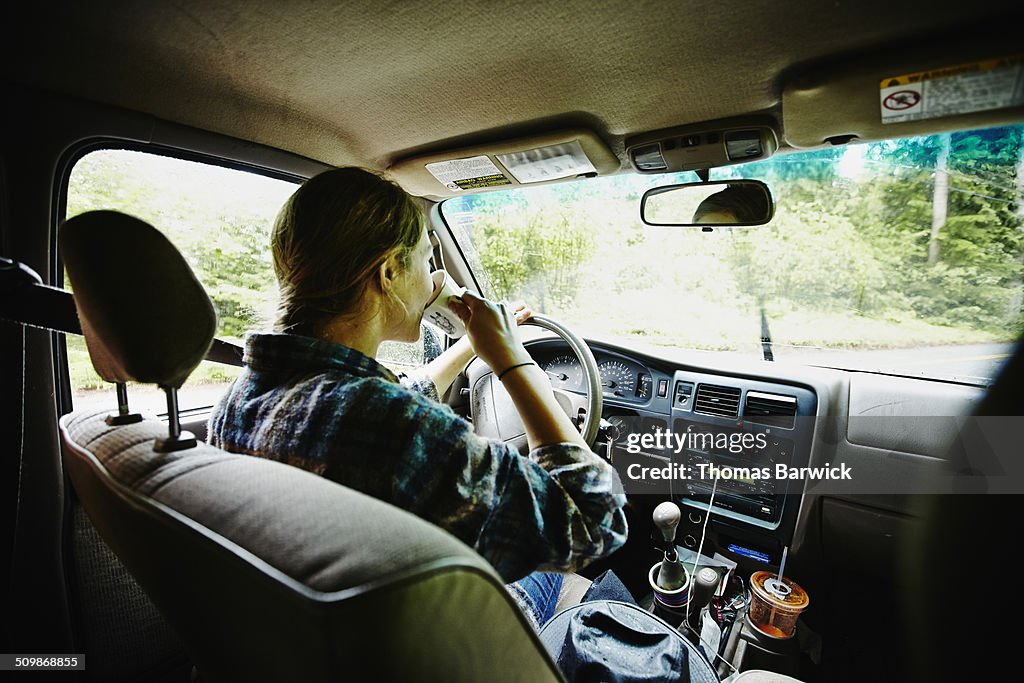Female farmer drinking coffee in pickup truck