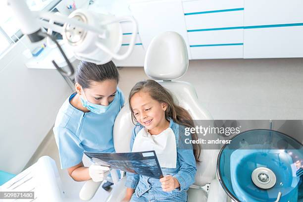 ragazza dal dentista che guarda la sua radiografia - dentista bambini foto e immagini stock