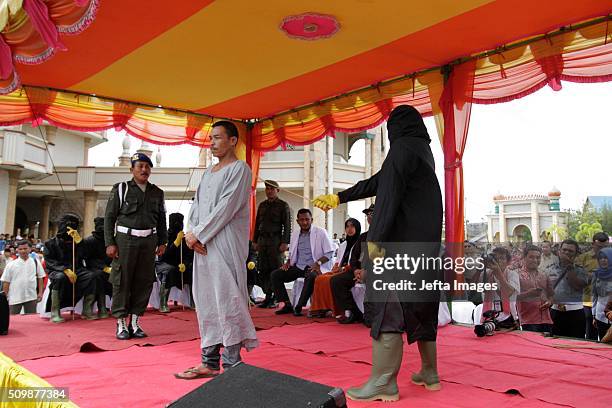 Man is whipped publicly in a caning ceremony at Meulabohm on February 12, 2016 in West Aceh, Indonesia. About 32 men in Aceh were publicly whipped on...