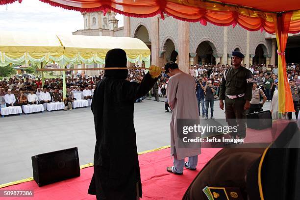 Man is whipped publicly in a caning ceremony at Meulabohm on February 12, 2016 in West Aceh, Indonesia. About 32 men in Aceh were publicly whipped on...