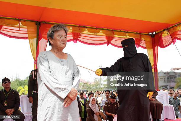 Man is whipped publicly in a caning ceremony at Meulabohm on February 12, 2016 in West Aceh, Indonesia. About 32 men in Aceh were publicly whipped on...