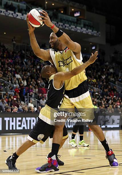 Muggsy Bogues'3'' of Team USA and Tracy McGrady of Team Canada battle for position during the NBA All-Star Celebrity Game at the Ricoh Coliseum on...