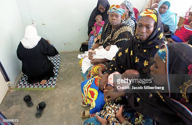 Nurse prays while mothers wait to have their children immunized against a series of diseases except polio at the Murtala Mohammed Hospital May 25,...