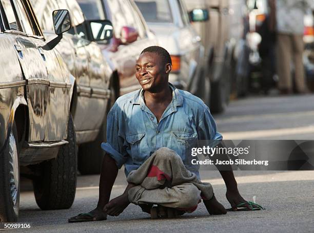 Man crippled by polio rides a skateboard through traffic November 12, 2003 in Lagos, Nigeria. The polio virus often causes wasting of the lower...