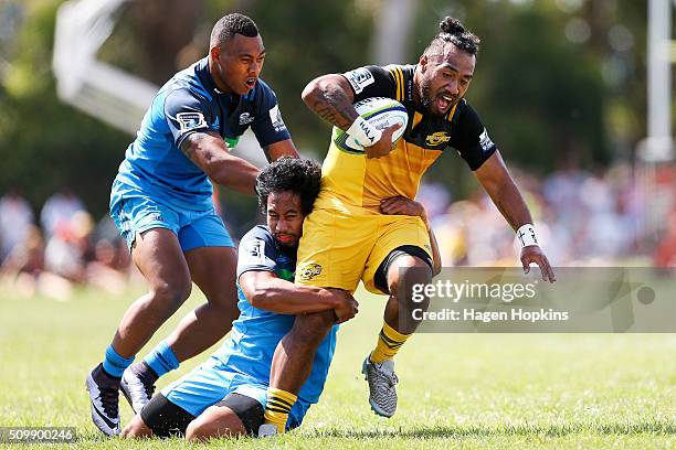 Matt Proctor of the Hurricanes is tackled by Tevita Li and Matt Vaega of the Blues during the Super Rugby pre-season match between the Blues and the...