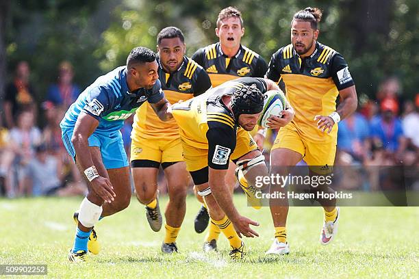 Callum Gibbins of the Hurricanes is brought down by Lolagi Visinia of the Blues during the Super Rugby pre-season match between the Blues and the...