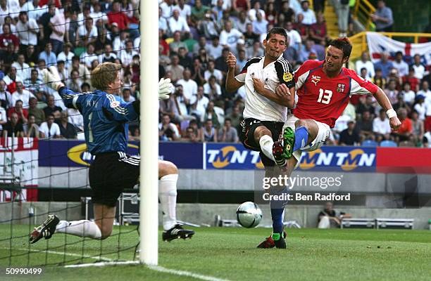 Martin Jiranek of Czech Republic shoots past Kevin Kuranyi of Germany during the UEFA Euro 2004 Group D match between Germany and Czech Republic on...