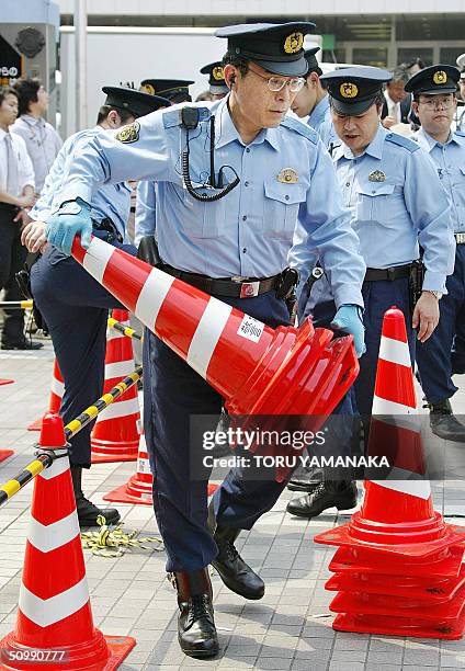 Policemen carry pylons to control traffic before a stumping tour by Katsuya Okada, leader of the main opposition Democratic Party of Japan, in Tokyo,...