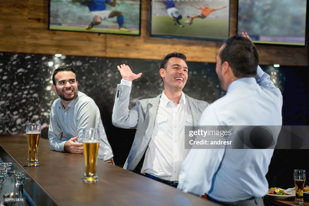 Happy business men having drinks at the bar