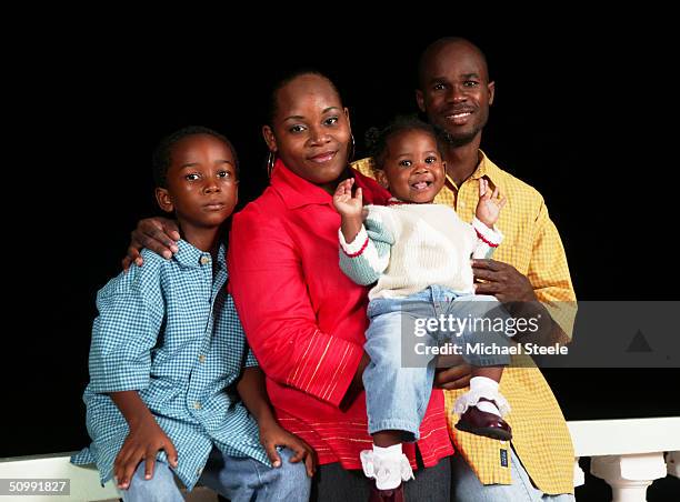 Kim Collins, 100m sprinter of St Kitts and Nevis and Olympic contender for Athens at home with his girlfriend Isis, and children Kiaun and Zan on...