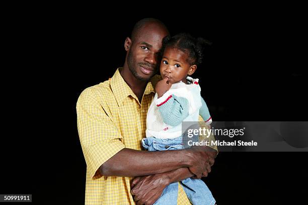 Kim Collins, 100m sprinter of St Kitts and Nevis and Olympic contender for Athens at home with daughter Zan on April 21, 2004 in Frigate Bay,...