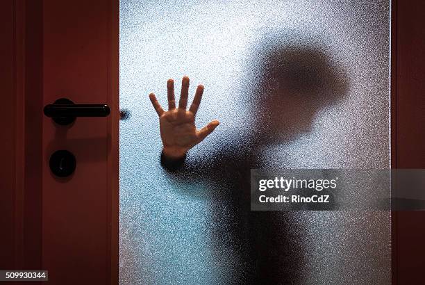 boy behind glass door - loneliness concept stockfoto's en -beelden