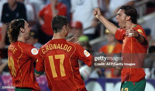 Portugal's forward Helder Postiga celebrates with his teammates forward Cristiano Ronaldo and midfielder Maniche after scoring against England, 24...