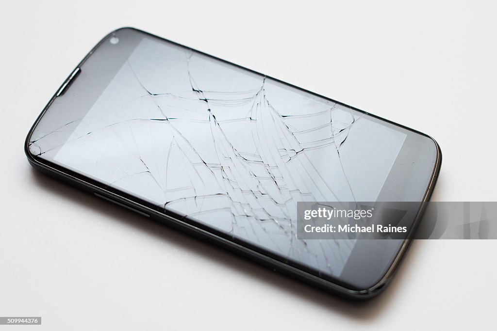 Smartphone with cracked screen on white background
