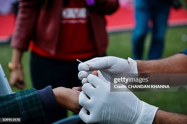 An Indian nurse carries out tests for HIV/AIDS during an event to promote the prevention of sexually transmitted diseases , and unwanted...