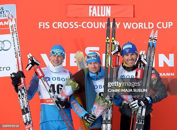 Winner Russia's Maksim Vylegzjanin poses on the podium with his compatriot second placed Aleksandr Bessmertnych and third-placed Maurice Manificat of...