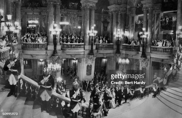 Queen Elizabeth II, ascending the Grand Staircase at the Opera in Paris during a state visit to the French capital, 8th April 1957. The image is a...