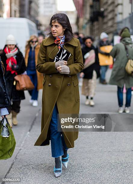 Manrepeller Leandra Medine wearing an olive wool coat, a zebra patterned clutch and an orange blue black patterned scarf seen outside Creatures of...