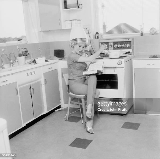 Barbara Roscoe does a spot of cooking while under a hairdryer at her...  News Photo - Getty Images