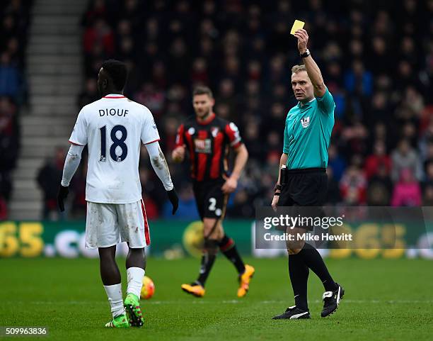 Mame Biram Diouf of Stoke City is shown a yellow card by referee Graham Scott during the Barclays Premier League match between A.F.C. Bournemouth and...