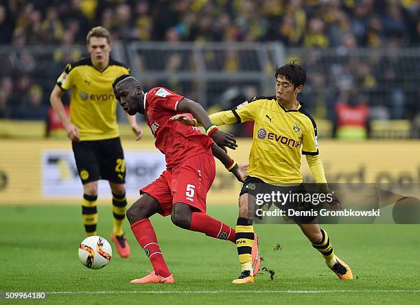 Shinji Kagawa of Borussia Dortmund challenges Salif Sane of Hannover 96 during the Bundesliga match between Borussia Dortmund and Hannover 96 at...