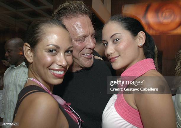 Actor Mickey Rourke poses with Michelle Pooch and a friend at Metro Lounge June 8, 2004 in Miami Beach, Florida.