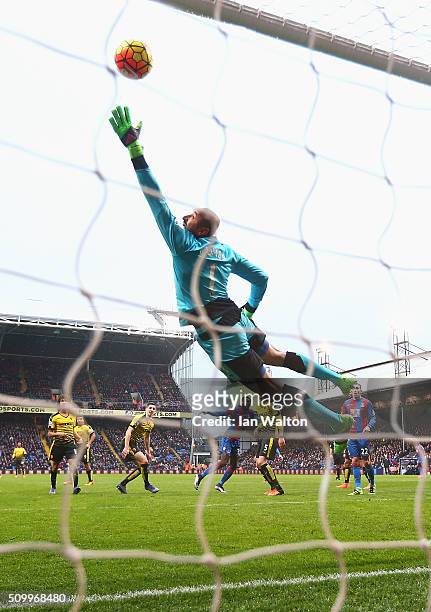 Heurelho Gomes of Watford dives in vain as Emmanuel Adebayor of Crystal Palace scores his team's first goal during the Barclays Premier League match...