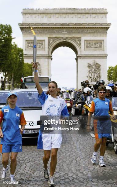 Coca-Cola torchbearer, Adeline Mendoza, carries the Olympic Flame during the ATHENS 2004 Olympic Torch Relay, on June 25, 2004 in Paris, France. The...