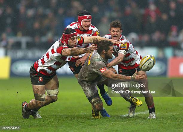 Luke Wallace of Quins passes the ball as the Gloucester defence gang up to bring him down during the Aviva Premiership match between Gloucester Rugby...