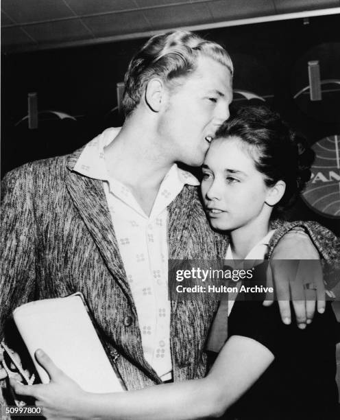 American rock musician Jerry Lee Lewis hugs his second cousin and third wife Myra Brown as they arrive in the airport from London after his tour of...