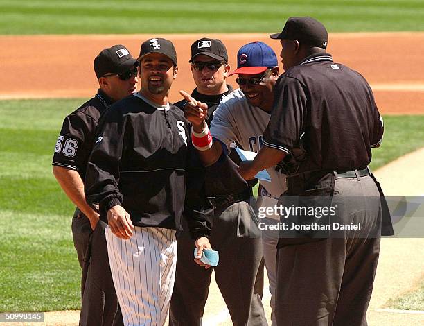Manager Ozzie Guillen of the Chicago White Sox and manager Dusty Baker of the Chicago Cubs clown with the umpires before a game on June 25, 2004 at...